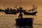 Fisherman Silhouette Rows in Round Boat with Paddle at Sunset