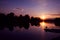 Fisherman silhouette on sunset background. Friends fishers enjoy fishing on river dock.