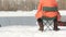 A fisherman sits on a stool and catches fish in the winter. River flow. Slow motion