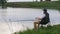 Fisherman sitting on a chair with a fishing rod on the lake