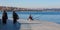 Fisherman sitting at Seafront Promenade and Muslim dressed Ladies walking