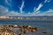 A fisherman sitting on stones on the shore of Gulf of Corinth, Greece