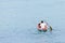 Fisherman in a small boat floats on the water ocean casts network fish extraction background walk fishing village copy space