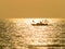 Fisherman on small fishing boat on a golden glittering sea