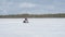 fisherman on a snowmobile rides on a winter lake. winter landscape
