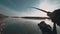 Fisherman spinning a powerful predatory fish from a boat at sunset