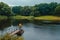 Fisherman standing on pier of the lake and fishing on rainy day