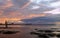 A fisherman stands on the rocks in front of the port of Torrevieja before sunrise.