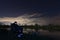 Fisherman in Starry Night, Sitting in chair looking on rods, patience