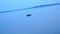 Fisherman swimming on inflatable rafting rubber boat on lake water surface at morning.