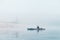 Fisherman swims on a kayak on the river