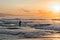 A fisherman throws a net into the sea at dawn. Beautiful sunrise at Pantai Pabean Ketewel Beach on the east coast of Bali.