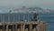 Fisherman works on wharf / pier, Alcatraz prison partially shrouded in backdrop