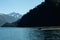 Fishermen in a boat navigating a lake with snowy mountain ranges in the background. Los Alerces National Park