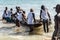 Fishermen in a canoe into the sea for delivery of Iemanja gifts at Boca do Rio beach