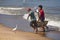 Fishermen carrying fish in baskets.