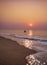 Fishermen coming back by boat to sea beach during early morning Sunrise time from the ocean.