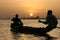 Fishermen crossing a lake at sunset