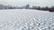 Fishermen engaged in ice fishing in winter. Frozen river and city.