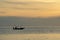 Fishermen fishing on a boat silhouette in morning sunrise light.