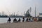 Fishermen fishing with a rod at the pier in the seaport on a warm windless autumn day