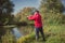 Fishermen fishing with a spinning rod from the shore on a sunny day. Fishing on a sunny day. Man on the river bank throws a