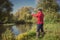 Fishermen fishing with a spinning rod from the shore on a sunny day. Fishing on a sunny day. Man on the river bank throws a