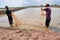 Fishermen are harvesting shrimp from their pond by fishing nets in Bac Lieu city