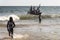 Fishermen inside canoes at sea paddling against the tide