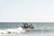 Fishermen inside canoes at sea paddling against the tide