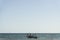 Fishermen inside canoes at sea paddling against the tide