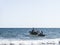 Fishermen inside canoes at sea paddling against the tide