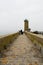 Fishermen on pier near a beacon light