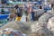 Fishermen repairing their net at the fishing port, with colorful fishing nets around them