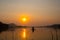 Fishermen\\\'s boats gently glide on the reservoir\\\'s calm waters during sunrise