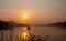 Fishermen\\\'s boats gently glide on the reservoir\\\'s calm waters during sunrise and the stillness