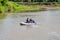 Fishermen sail in an inflatable boat with an outboard motor on a summer river