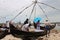 Fishermen sell the fish to customers against the backdrop of massive Chinese fishing nets