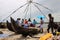 Fishermen sell the fish to customers against the backdrop of massive Chinese fishing nets