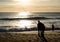 Fishermen silhouette on beach at sunset, Algarve, Portugal.