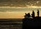 Fishermen silhouettes at the sunrise on the dock