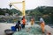 Fishermen take out catch from fishing net on pier in ocean bay surrounded by green hills.