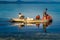 Fishermen on a traditional wooden boat floating on a calm sea