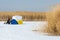 Fishermen. winter. tent for winter fishing. Reeds on a frozen la