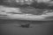 Fishermens boat at seacoast, on sand at sunset with horisont sea on background. Background of sea with waves and sky