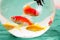 Fishes in a round glass bowl red carps green backg