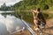 Fishing adventures, carp fishing. Angler with camouflage t-shirt is feeding fishes throwing boilies with a slingshot