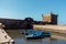 Fishing beautiful blue boats, gear and catch on background of Castelo Real of Mogador in Essaouira old harbor