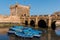 Fishing beautiful blue boats, gear and catch on background of Castelo Real of Mogador in Essaouira old harbor