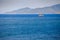 fishing boat amidst azure sea against hilly tropical island